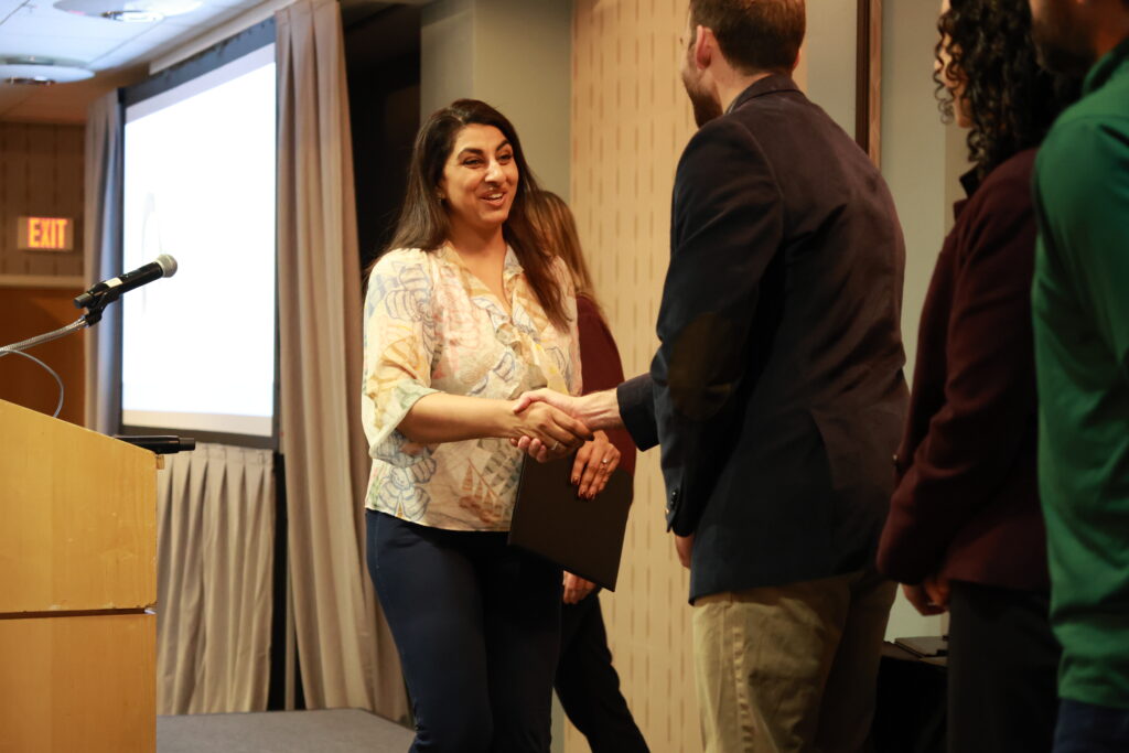 Ivy Health team member greeting a healthcare professional with a handshake during an industry event