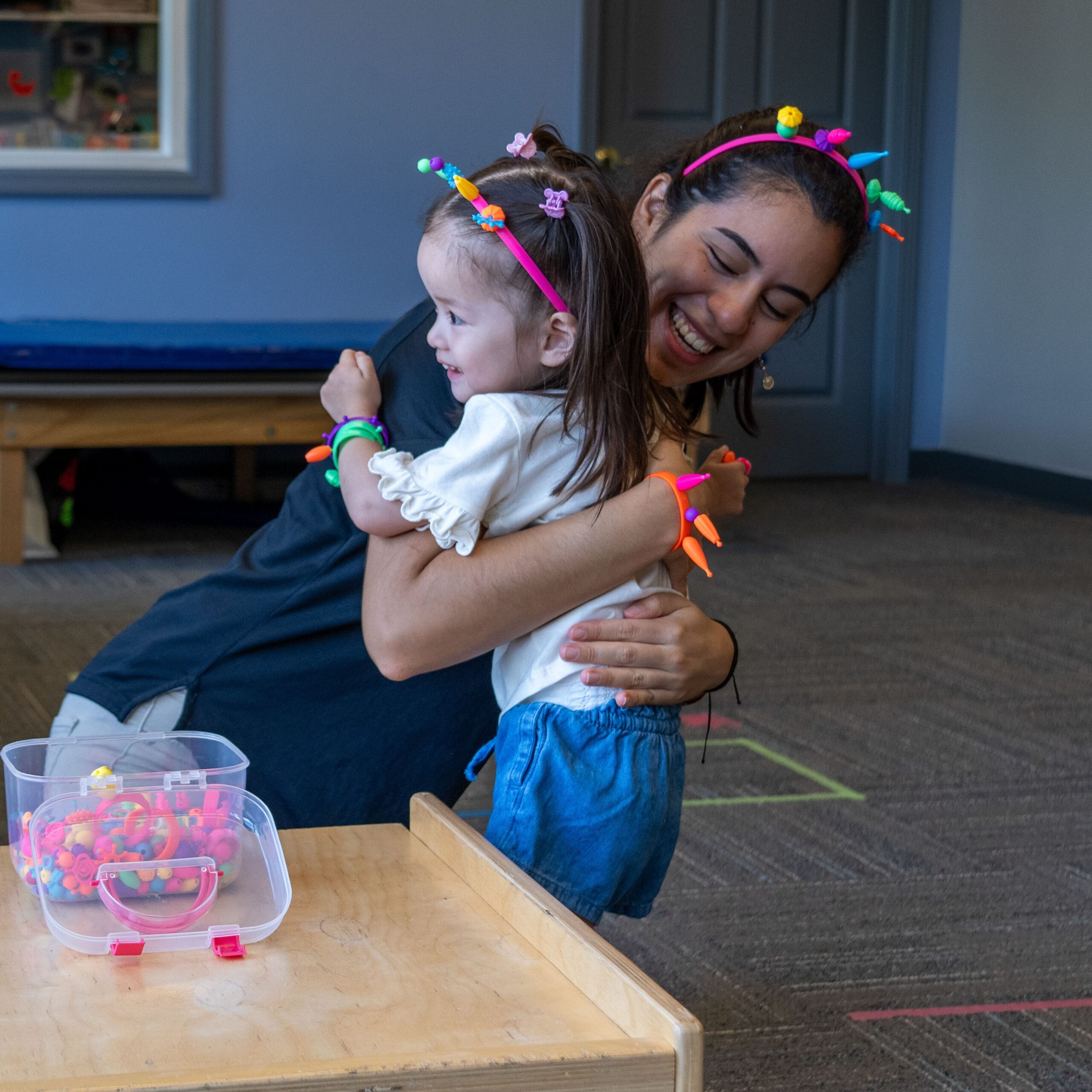 Pediatric therapist encouraging a child during a fun, play-based therapy session