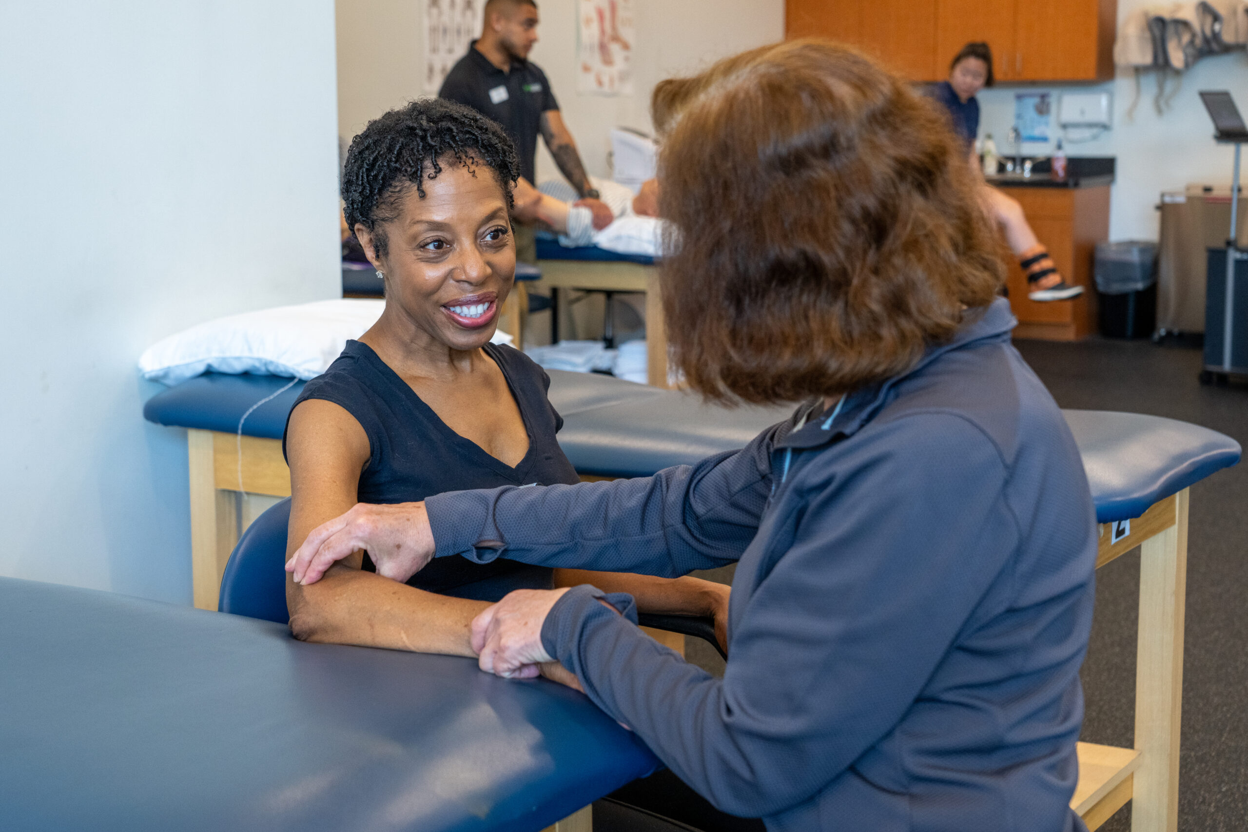 Physical therapist speaking with a patient during a rehabilitation appointment