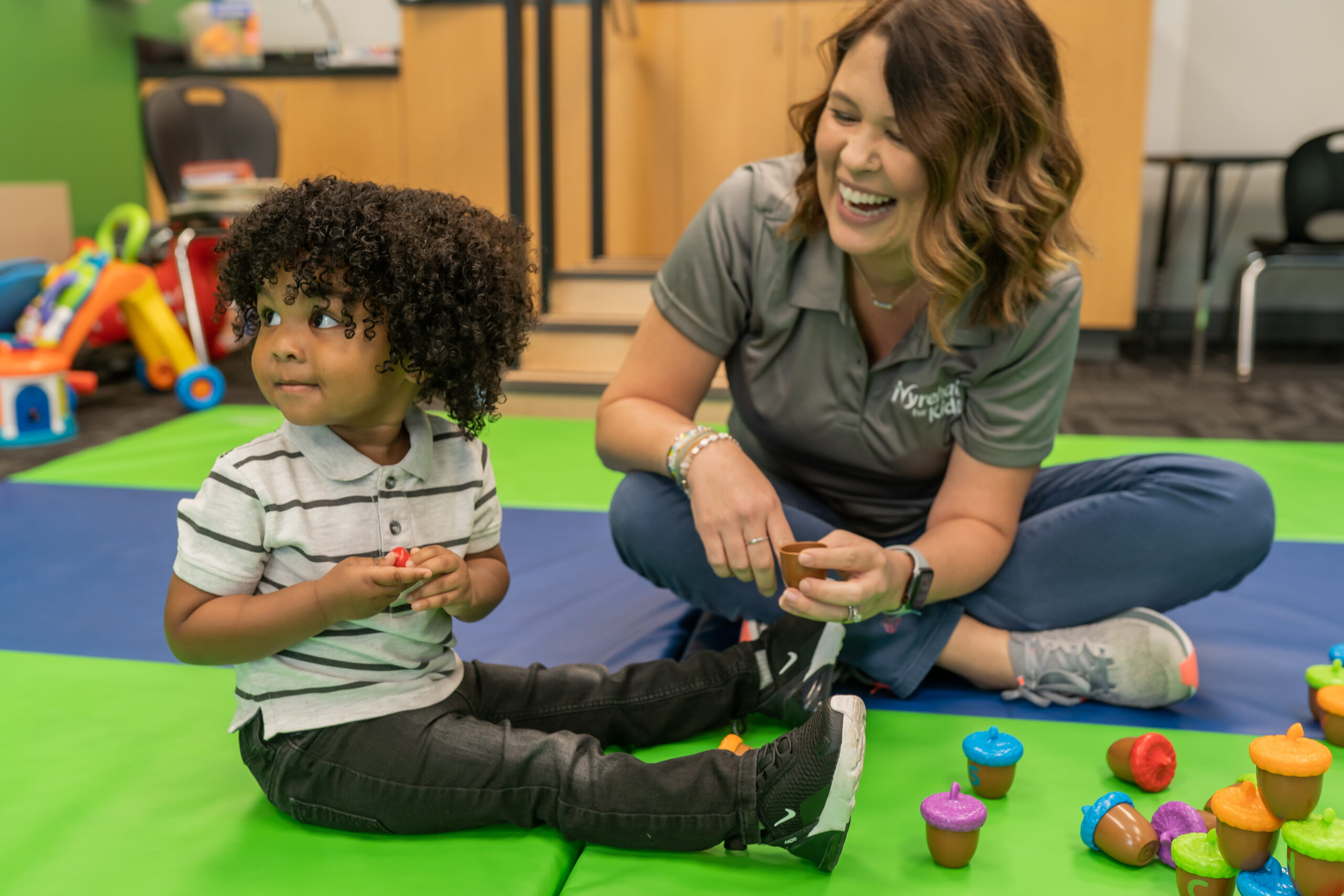 Pediatric occupational therapist playing with a child during a therapy session