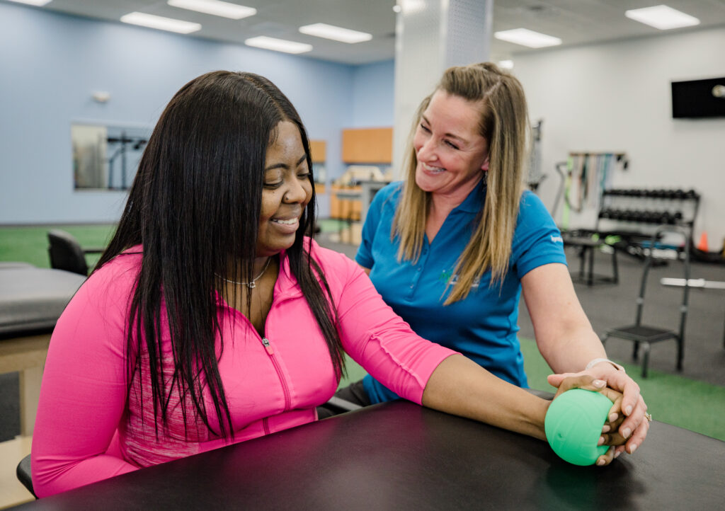 Physical therapist leading work conditioning exercises to build upper body strength for work tasks