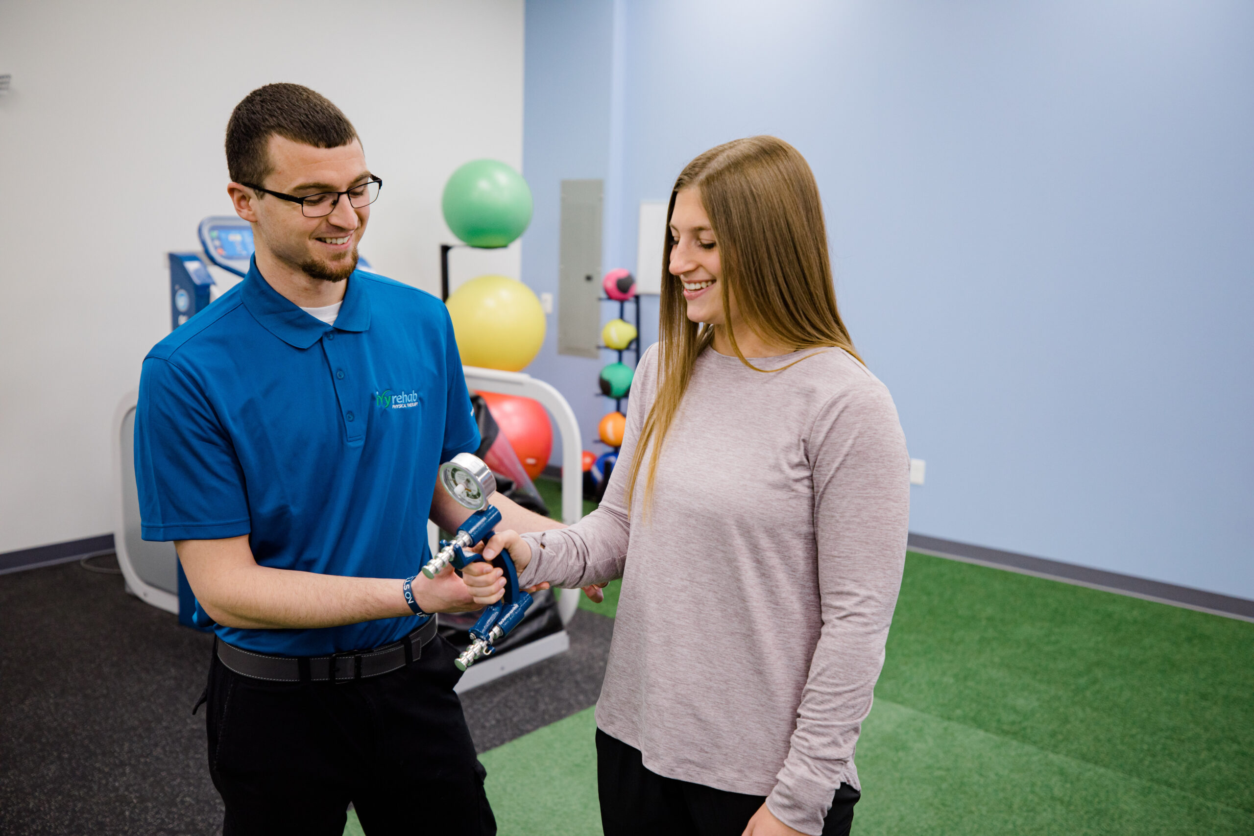 Clinician assessing a patient's grip strength with a hand dynamometer