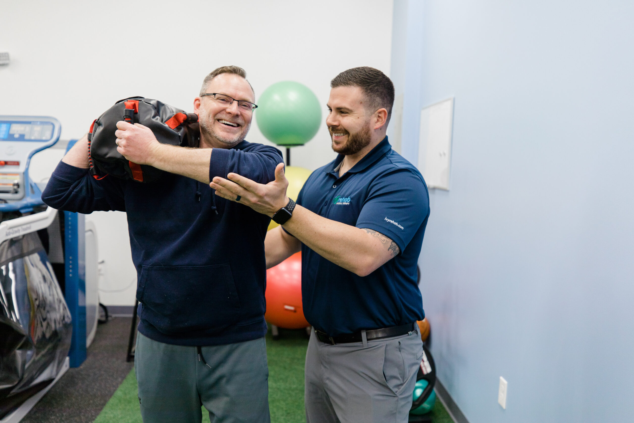Therapist assisting a patient with an upper-body resistance exercise using a cable machine