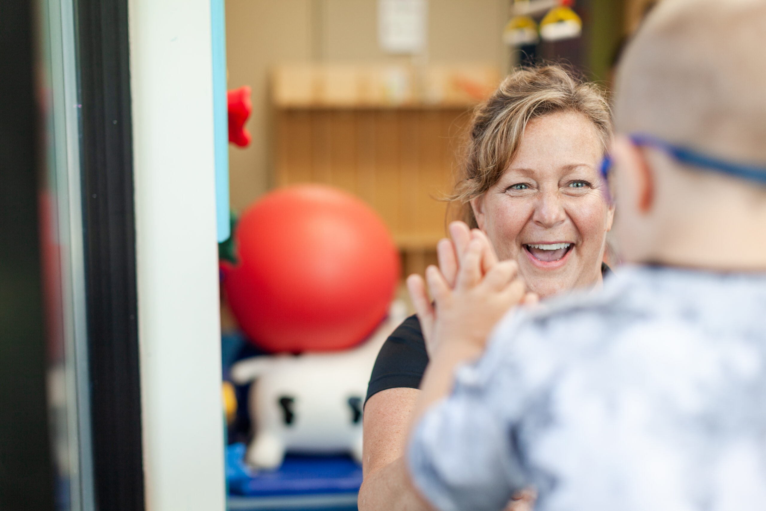 Physical therapist high fiving a pediatric patient during an appointment