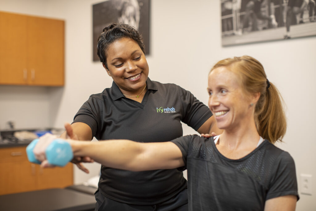 Physical therapist guiding a patient through office ergonomics exercises to reduce shoulder pain