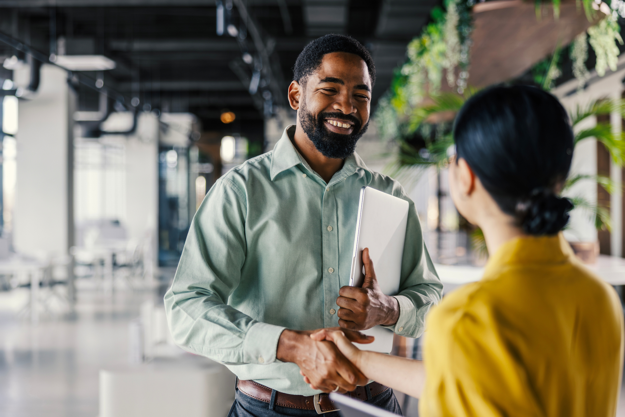 Man and woman shaking hands during a meet for a physical therapy network partnership.